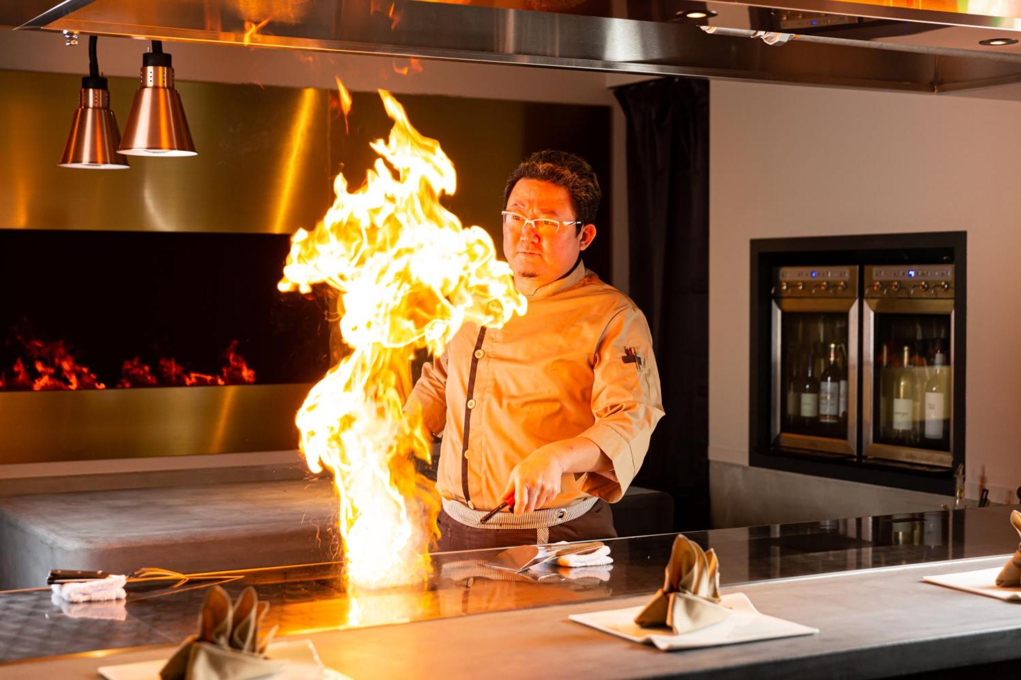 Good Nature Hotel Kyoto Exteriör bild A chef cooking with a flaming torch